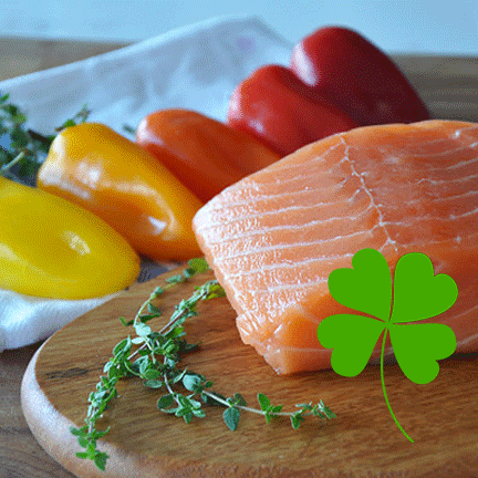 a piece of salmon with a shamrock and fresh peppers