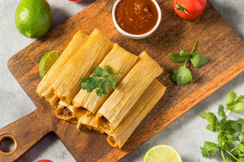 tamales stacked on a cutting board